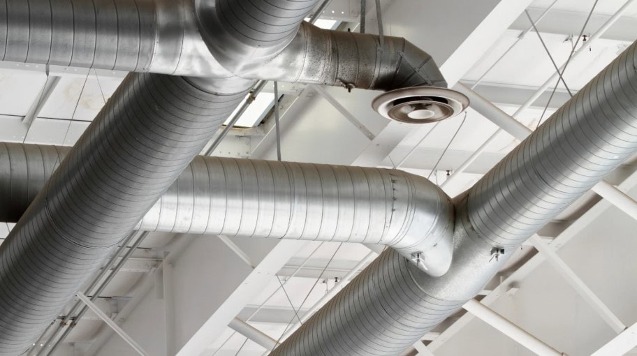Industrial ceiling with silver ventilation ducts and support beams