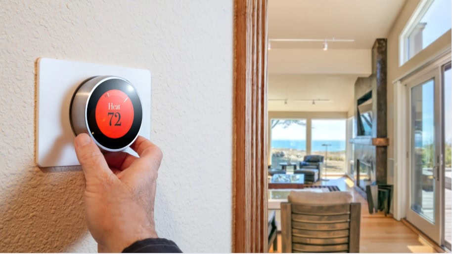 Hand adjusting smart thermostat in modern home HVAC maintenance concept